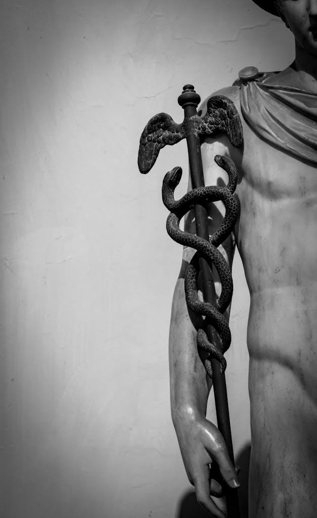Black and white photo of Roman statue featuring the Caduceus symbol, symbolizing commerce and negotiation.